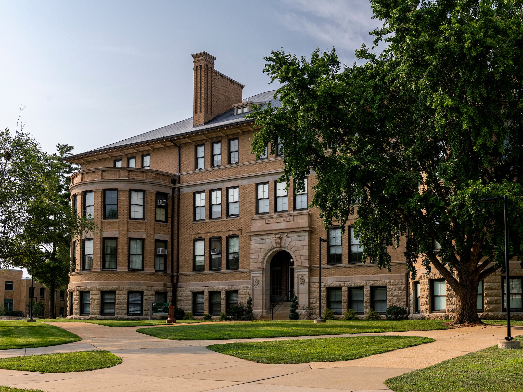 Exterior of Norwood hall, a stone building with trees on the right side